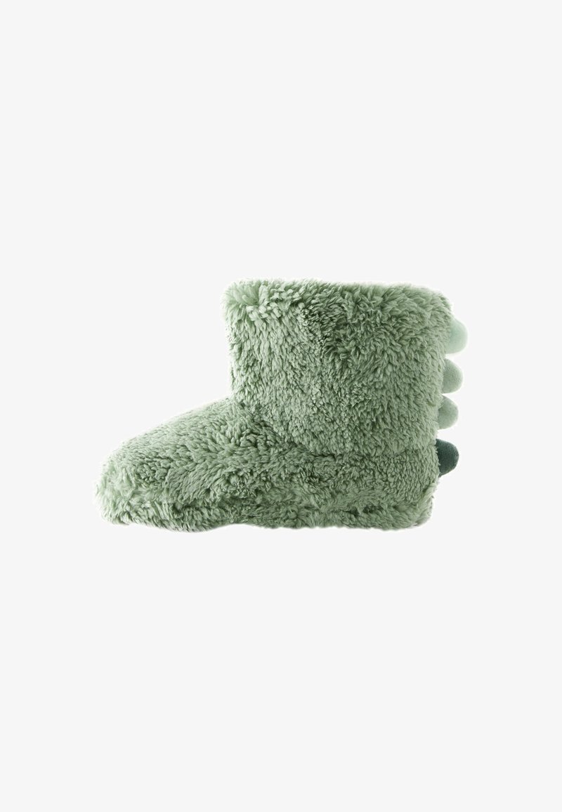 Chausson en polaire vert avec une texture duveteuse ; forme arrondie, arbore trois pompons à l'arrière. Design doux et confortable.