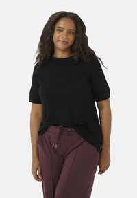Sort t-shirt med korte ærmer og rund halsudskæring, parret med bordeauxfarvede bukser med snøre. Toppen har en afslappet pasform og blød tekstur.