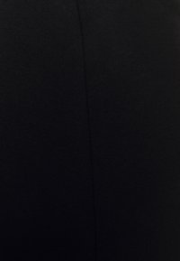 Černé legíny vyrobené z elastické tkaniny, s hladkou, rovnoměrnou strukturou a horizontálním švem na boku pro přiléhavý design.