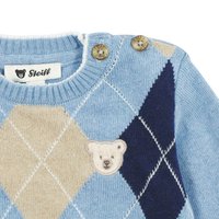 Blauer Strickpullover mit Rautenmuster in Beige und Marineblau, ausgestattet mit einem gestickten Bärenpatch und zwei dekorativen Knöpfen an der Schulter.
