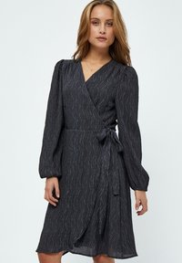 Tummanharmaa kietaisumekko, jossa on pitkät hihat, teksturoitu kangas, jossa on herringbone-kuvio, ja sivusolmu säädettävää istuvuutta varten.