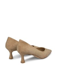 Zapatos de tacón alto de ante beige con punta afilada y un diseño de tacón angular único. Textura suave con un acabado mate.
