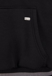 Černá mikina s kapucí, která má přední kapsu, pružný lem s šedými akcenty a stříbrnou nášivku na kapse s názvem značky.