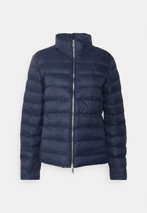 Doudoune matelassée bleu marine avec col montant, fermeture éclair frontale argentée à double sens, manches longues et motif de couture horizontale.