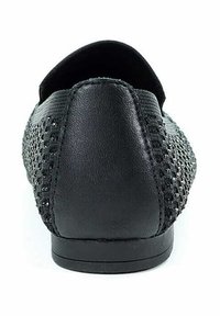 Scarpa nera slip-on con tomaia in rete texturizzata, tacco in pelle liscia e suola piatta in gomma con dettagli minimi.