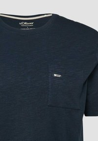 T-shirt à manches courtes bleu marine avec encolure ronde et poche poitrine gauche ornée d'une petite étiquette "Elevated Casual".