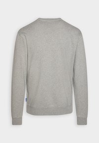Felpa grigia con collo tondo, maniche lunghe e polsini a coste. Realizzata in materiale morbido con una texture liscia e senza motivi o logo visibili.
