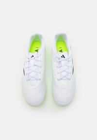 Zapatillas deportivas blancas con parte superior sintética suave, acentos negros en contraste y plantilla verde neón. Diseño de cordones y forma de punta redondeada.