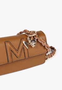 Borsa in pelle color cuoio con finitura testurizzata, caratterizzata da un evidente 'M' in rilievo, hardware dorato e un charm decorativo a forma di testa di leopardo.