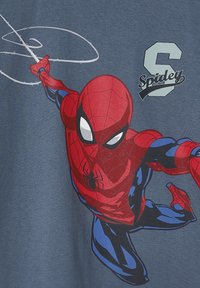 Red and blue cotton t-shirt featuring a large Spider-Man graphic, with action pose and web detail, set against a gray background.