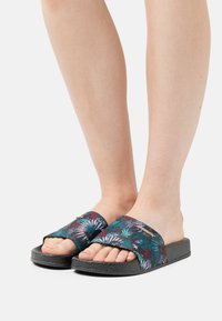 Sandali neri a scivolo con motivo floreale in tonalità di verde, blu, rosso e bianco; suola testurizzata; design open-toe con fasce larghe.