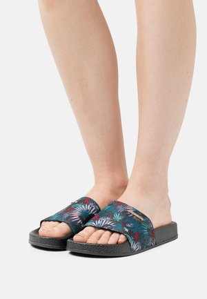 Black slide sandals with a floral pattern in shades of green, blue, red, and white; textured outsole; open-toe design with wide straps.