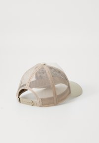Beige mesh cap with a solid light beige front panel and curved brim, featuring a snapback closure and a decorative top button.