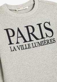 Grijze sweatshirt van katoen met een geribbelde halslijn. Bevat "PARIS LA VILLE LUMIÈRES" in zwarte, vetgedrukte typografie.