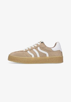 Beige lage sneaker met patroonstof, gumzool, witte veters, witte hielpatch en twee witte golvende zijstrepen.
