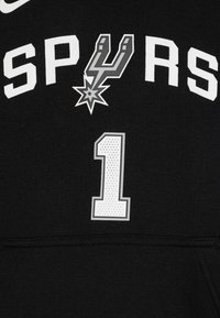Felpa nera con cappuccio caratterizzata da grande testo bianco "SPURS", un logo argento a forma di stella e il numero "1" in un design perforato grigio e bianco.