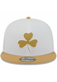 Weißes Snapback-Cap mit goldenem dreiblättrigem Kleeblatt-Logo, beiger Schirm, strukturierter Stoff und gestickte Details auf dem vorderen Panel.