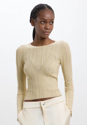 Top beige a maniche lunghe a costine con silhouette aderente, caratterizzato da un sottile dettaglio a forma di V sul petto e tessuto testurizzato.