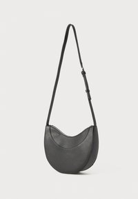 Black leather handbag with a curved shape, adjustable strap, and a zipper closure. Smooth texture with minimalistic design.