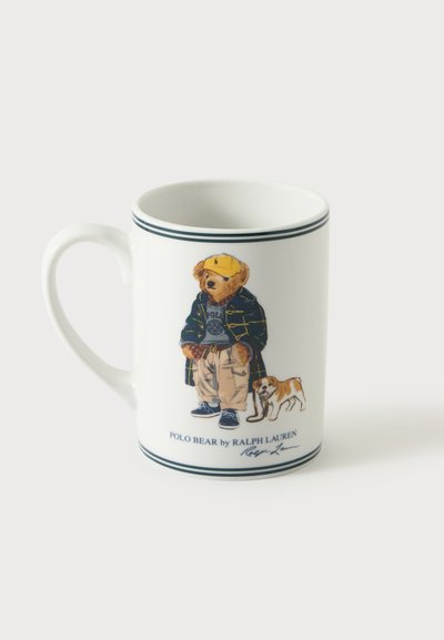 Λευκή κεραμική κούπα με μια εικόνα αρκούδας ντυμένης με καθημερινά ρούχα και μια μικρή σκυλίτσα στην μπροστινή πλευρά, με δύο λεπτές σκουρόχρωμες ρίγες κοντά στη στεφάνη και τη βάση.