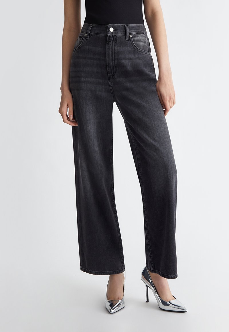 Jeans a vita alta e gambe larghe in denim grigio scuro, con chiusura a bottone, tasche frontali e una finitura pulita senza effetti di usura.