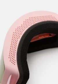 Roosa ja hall spordipeapael, millel on polsterdatud must sisemus, perforeritud välimus ventilatsiooni jaoks ja pehme elastne sulgur.