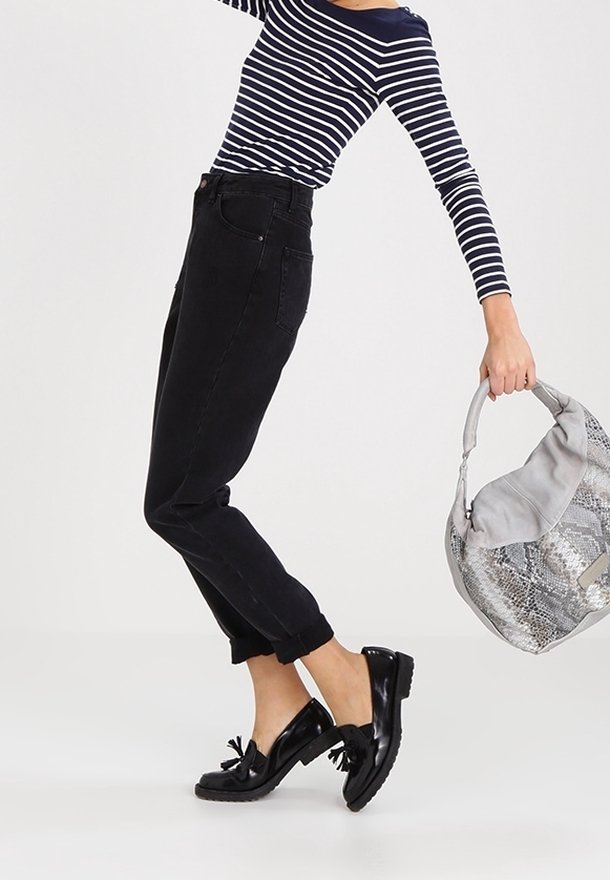 Black high-waisted jeans with rolled cuffs, paired with a navy and white striped long-sleeve top. Accessories include a gray handbag and shiny black shoes.