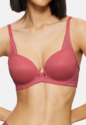 Mauve-pink bh med tekstureret honningkage-mønster, blonder langs kanterne og justerbare stropper. Har en lille sløjfedetalje i midten.