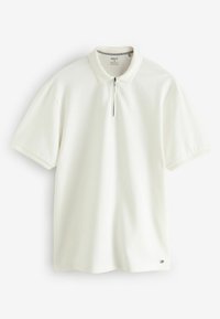 Witte polo met een ritskraag, korte mouwen en een textuurpatroon. Heeft subtiele branding aan de onderzoom.