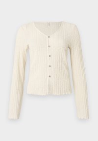 Cardigan à manches longues couleur ivoire avec un motif tricoté texturé, doté d'un col en V et de cinq boutons métalliques sur le devant. Ourlet festonné.