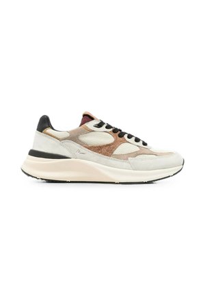 Lage sneaker met beige, bruine en witte mesh- en suèdepanelen, zwarte veters en een dikke crèmewitte zool op een witte achtergrond.