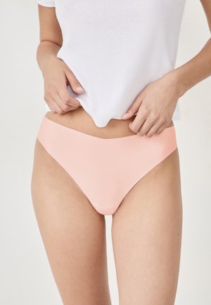 Peach-colored bikini bottom with a smooth, stretchy fabric. Features a minimalist design and low-rise cut.