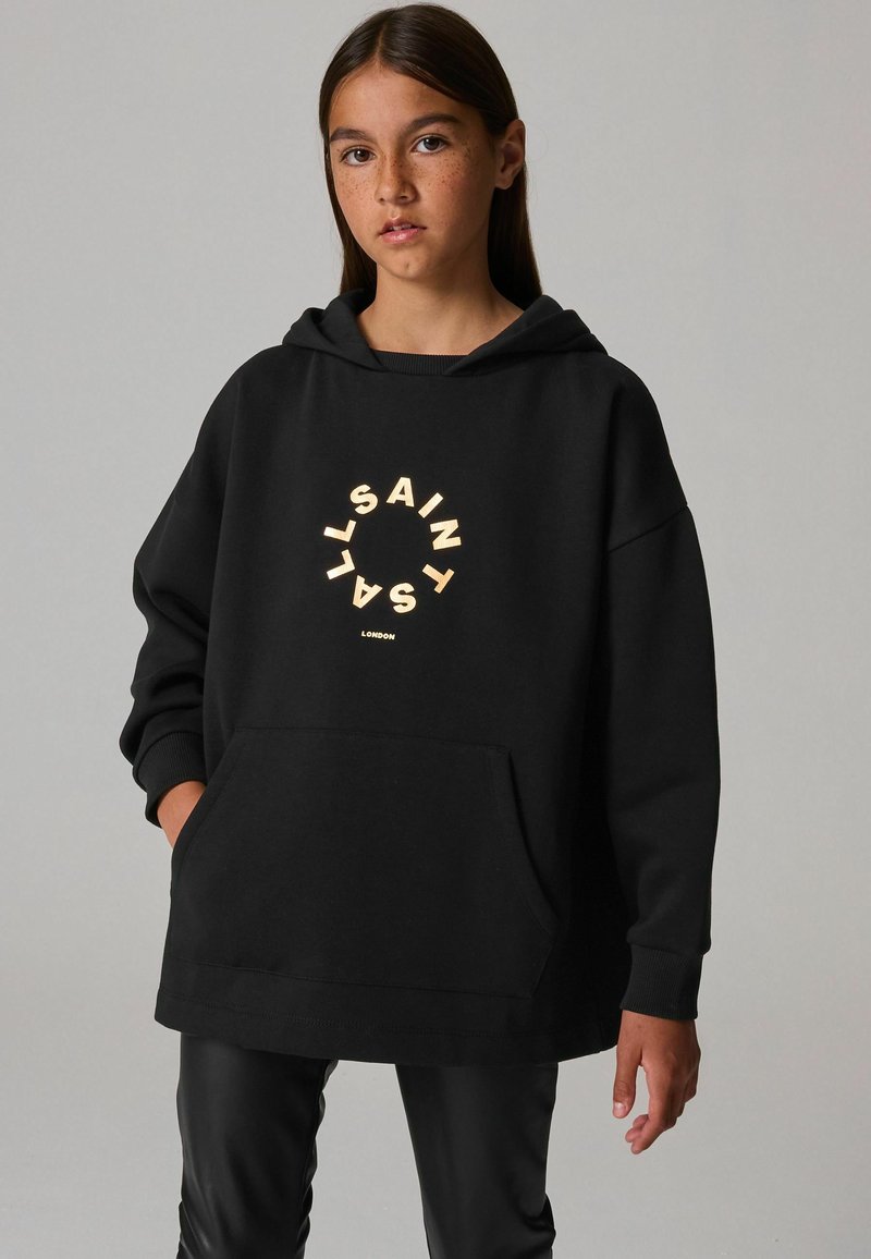 Sudadera con capucha negra que presenta un gran logo circular con el texto "SAINT" y "LONDON", fabricada en una tela suave, con un bolsillo frontal.