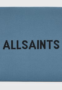 Tessuto intrecciato azzurro chiaro con grandi lettere nere che scrivono "ALLSAINTS." Texture liscia con un motivo a maglia uniforme su tutta la superficie.