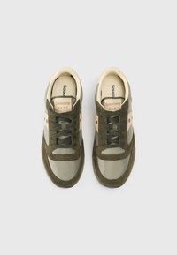 Rohelise ja beeži värvusega Saucony Jazz tossud, mis sisaldavad sujuvat ja tekstuurset materjalide segu, paelakinnitusega disaini ja logoga keelel.