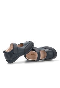 Zapatos infantiles de cuero negro con una correa de hebilla, punta redondeada, cuello acolchado y detalles texturizados a lo largo de las suelas.