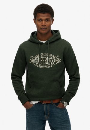 Mørkegrøn hættejakke med en lomme i fronten, prydet med et vintage-stil hvidt grafisk logo. Materialet virker blødt med en struktureret overflade.