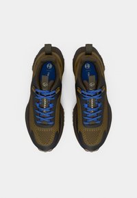 Braune und schwarze Sportschuhe mit blauen Schnürsenkeln und blauen Innensohlen, von oben auf einem weißen Hintergrund betrachtet.