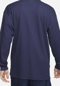 Námořnická košile s dlouhým rukávem vyrobená z texturované látky. Disponuje žebrovaným vzorem a kulatým výstřihem, má prodloužené rukávy a volný střih.