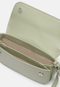 Grüne Leder-Crossbody-Tasche mit einer weichen Textur, ausgestattet mit einem magnetischen Druckverschluss und Innenfächern in einem helleren Farbton.