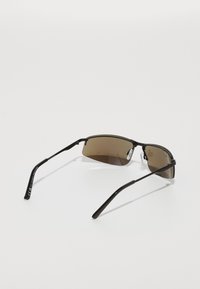 Schwarze Metal-Sonnenbrille mit braun getönten Gläsern, schlankem Drahtgestell, rechteckiger Form und gummierten Nasenpads für zusätzlichen Komfort.