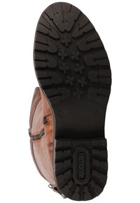 Semelle de botte en cuir marron avec une semelle extérieure en caoutchouc noir texturé présentant un motif de rainures et de crampons pour une meilleure traction. Logo de la marque visible.