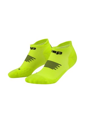 Ein Paar fluoreszierend gelber Knöchelsocken mit schwarzen Streifen und teilweise textlicher Markenkennzeichnung auf einem weißen Hintergrund.