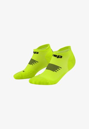 Pair of fluorescent yellow ankle socks with black stripes and partial text branding on a white background.