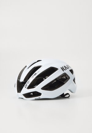 Casco de ciclismo blanco con forma alargada y aerodinámica, múltiples tomas de aire, acolchado interior negro y branding en el lateral.