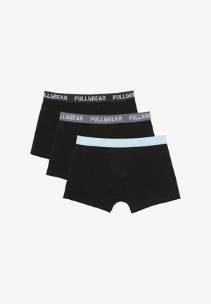 Trois boxers noirs pour hommes avec ceintures élastiques en noir, gris et bleu clair, chacun portant la marque "PULL&BEAR".