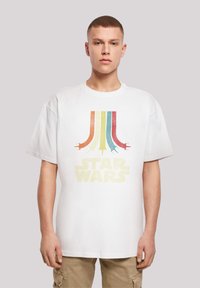 Biała bawełniana koszulka z krótkim rękawem, charakteryzująca się retro grafiką kolorowych pasków oraz napisem "STAR WARS" w kolorze żółtym. Luźny krój.