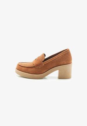 Brown suede loafers featuring a rounded toe and a front strap, set on a beige textured block heel. Smooth inner lining.