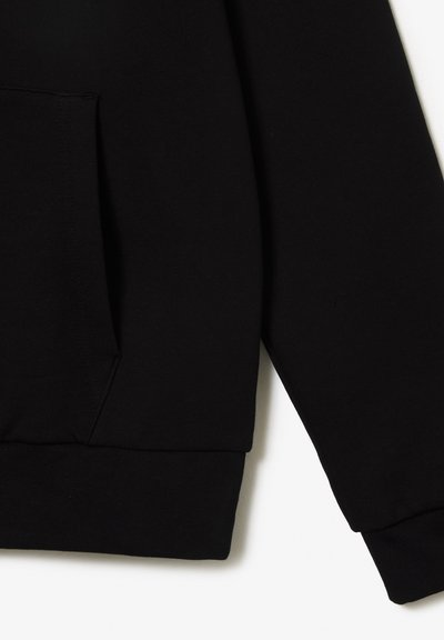 Sweat-shirt noir avec poche kangourou, poignets et ourlet côtelés. Matériau doux avec une texture lisse. Design simple sans motifs.