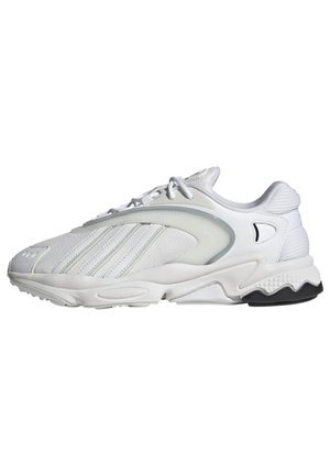 Biały sportowy sneaker z siateczkowymi i skórzanymi panelami, wiązaniem na sznurówki, wyściełaną podeszwą i czarnym gumowym detalem na spodzie.